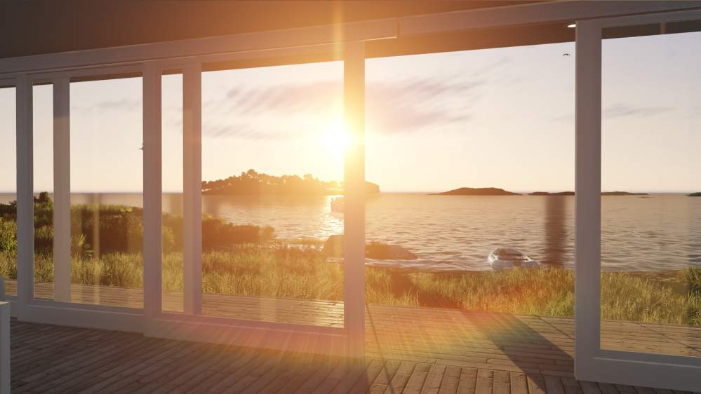 A wall of glass doors with the sun setting over the ocean