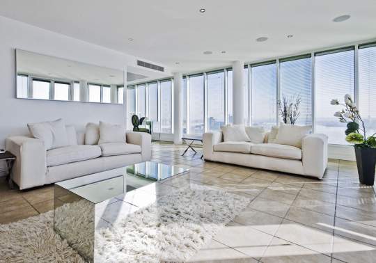 white sofa set in living room with large windows around the walls