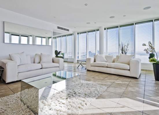 white sofa set in living room with large windows around the walls