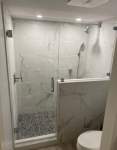 Shower enclosure with marble walls and glass door